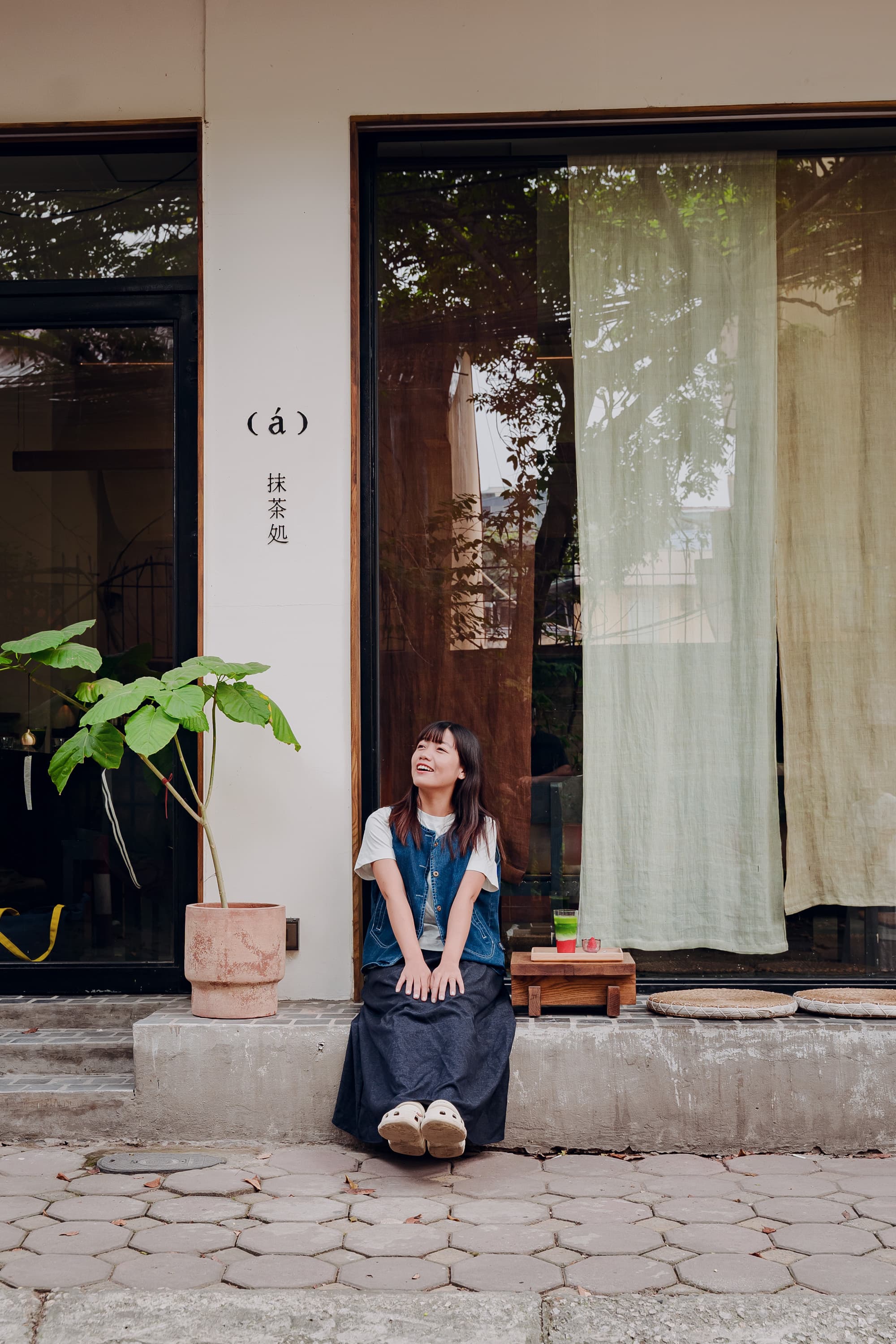 Xuân ngồi cười rạng rỡ trước hiên một quán trà nhỏ
